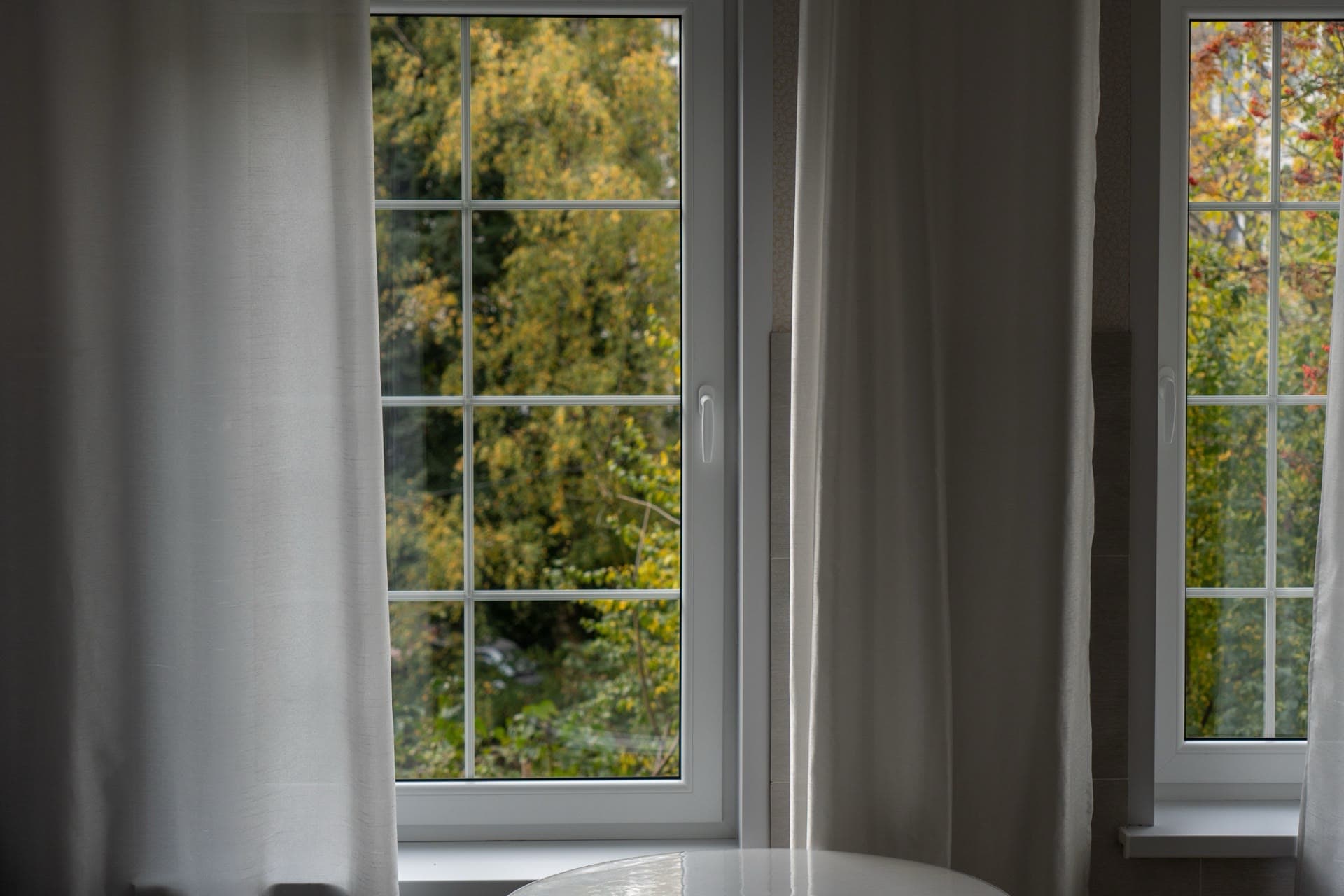 White-framed windows seen from a warm interior — frame area is typically a quarter to a third of the whole-window area on the EN reference size
