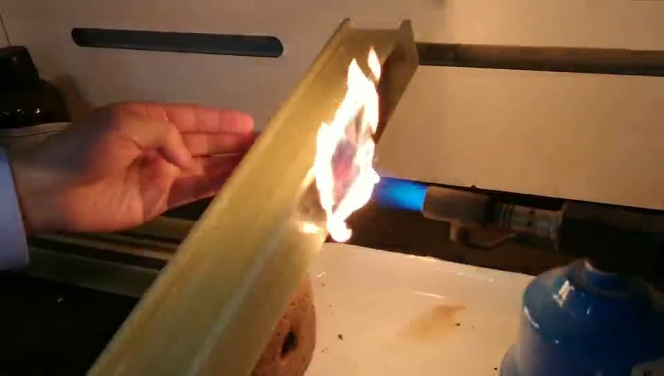 Pultruded FRP I-beam profile undergoing direct flame exposure test with a butane torch