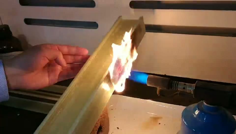 FRP composite profile showing char layer formation during sustained torch flame application