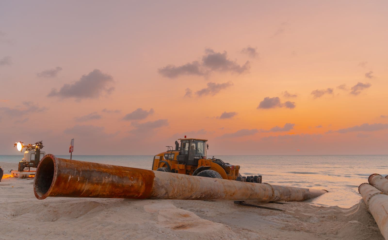 Large-diameter line pipe being installed at a pipeline construction site