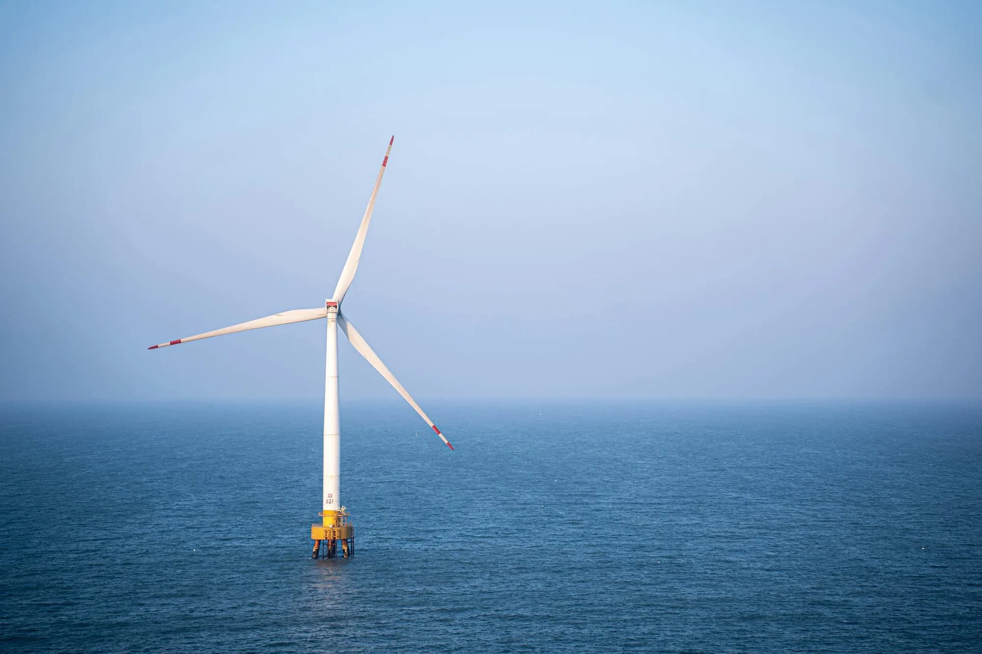 Solitary offshore wind turbine in calm sea — long-blade context for CFRP pultruded spar-cap laminates