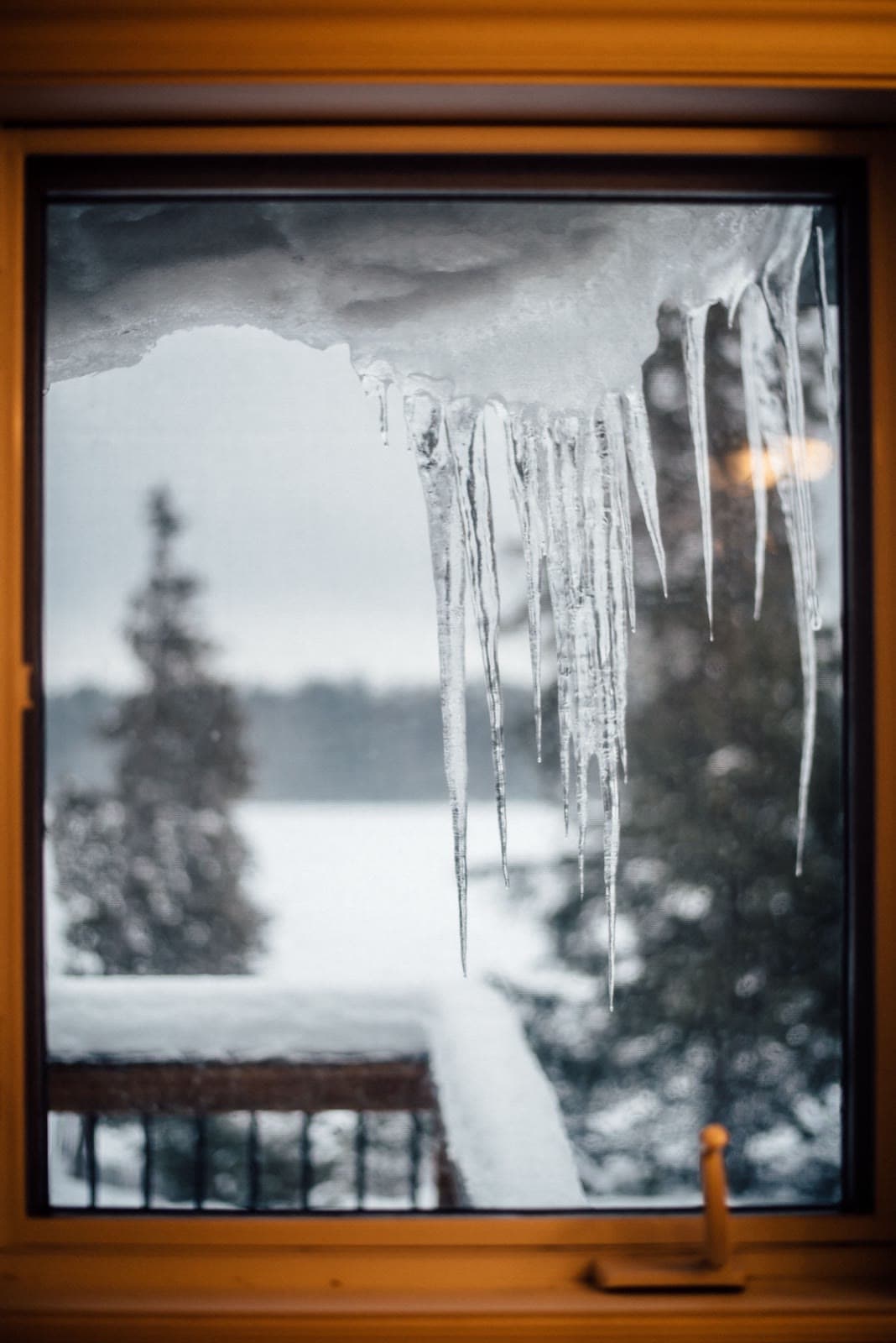 Icicles hanging in front of a window in deep winter — the design condition PHI's arctic and cold climate zone window criteria are written for