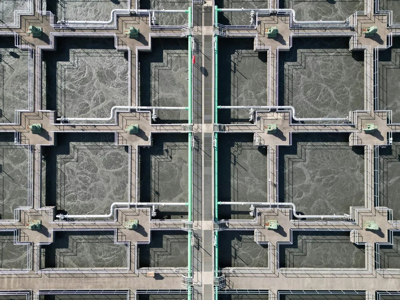 Aerial view of water treatment aeration basins with FRP cable tray and piping system installed across walkways