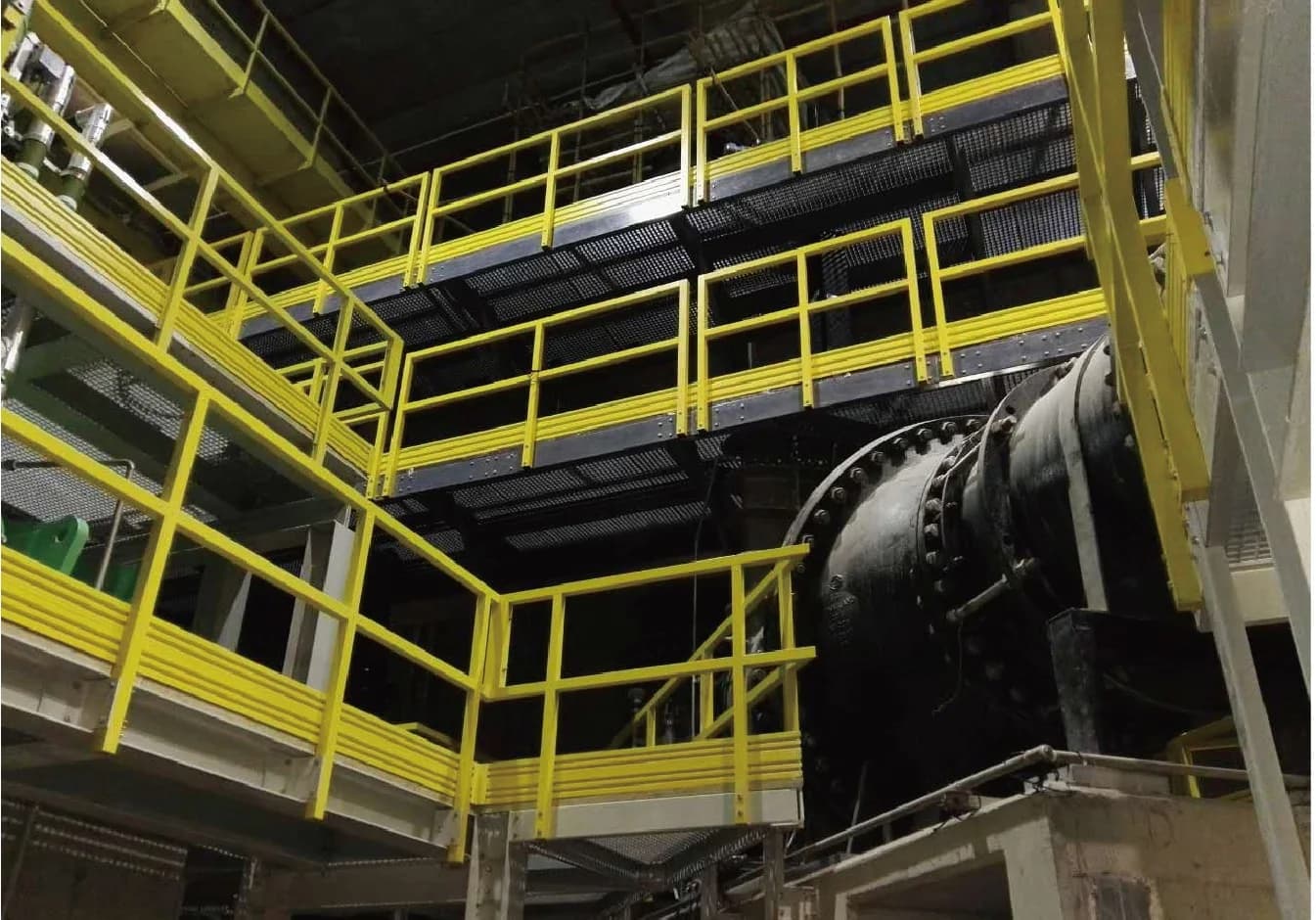 Yellow fiberglass handrails around industrial platforms and stairs