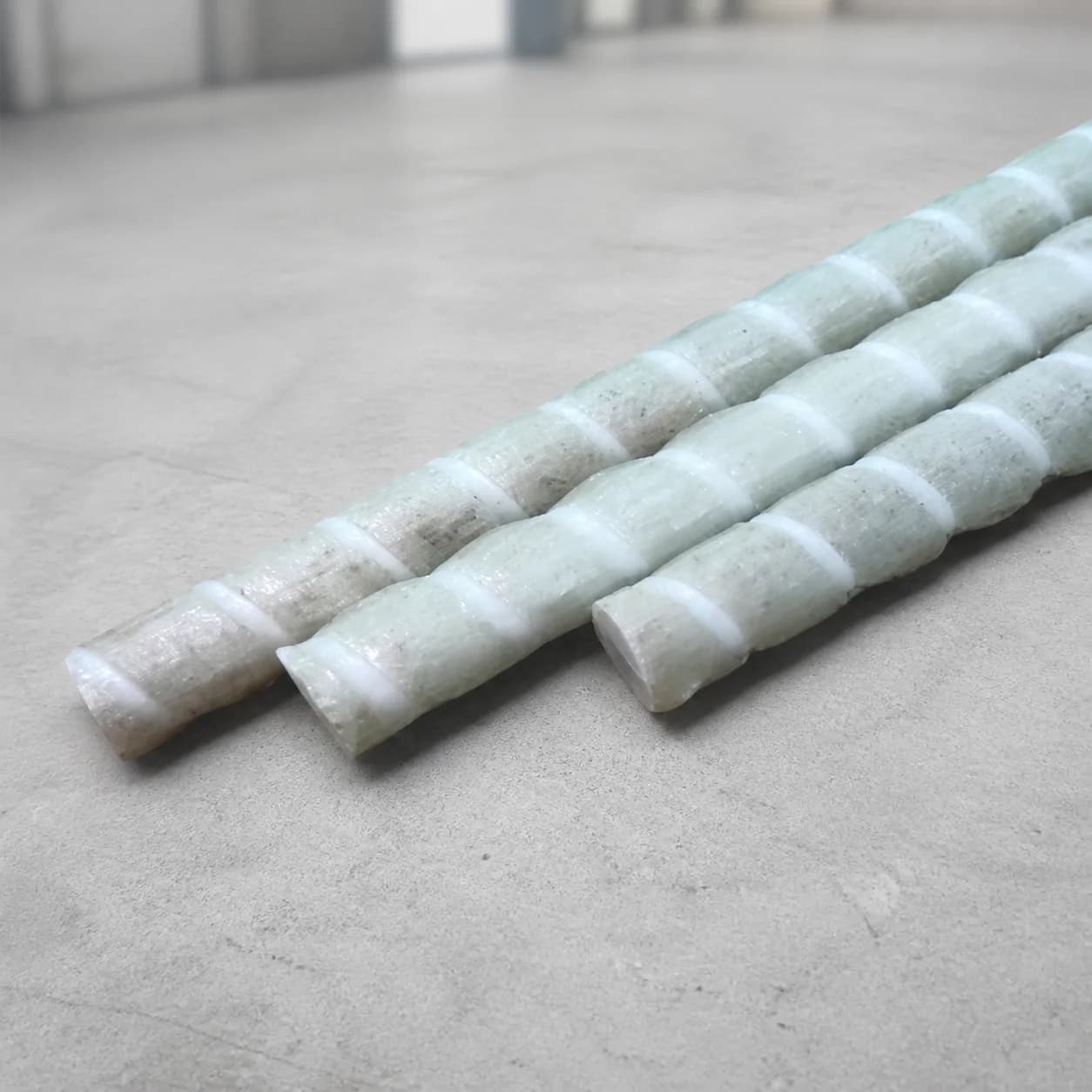 Three FRP rebars with helically wrapped concrete bond surfaces